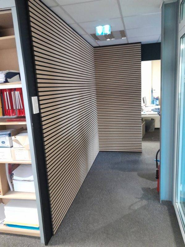 Pose bardage bois stratifié horizontal intérieur avec sous couche phonique dans un bureau de société à Strasbourg
